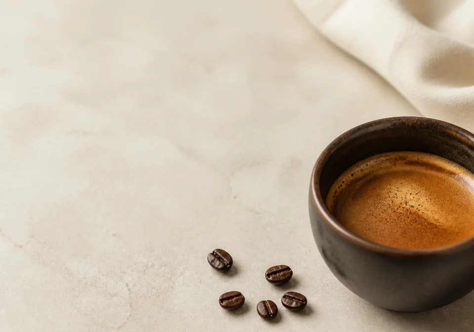 Close espresso detail on a quiet warm ivory surface.